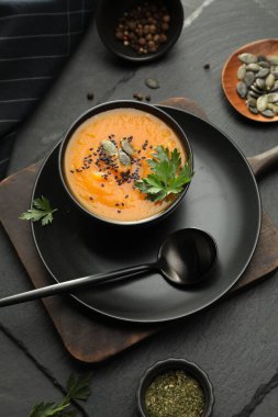 Koyu dokulu masada servis edilen baharatlı balkabağı çorbası.
