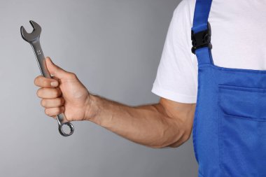 Gri arkaplanda ingiliz anahtarı olan oto tamircisi, kapat