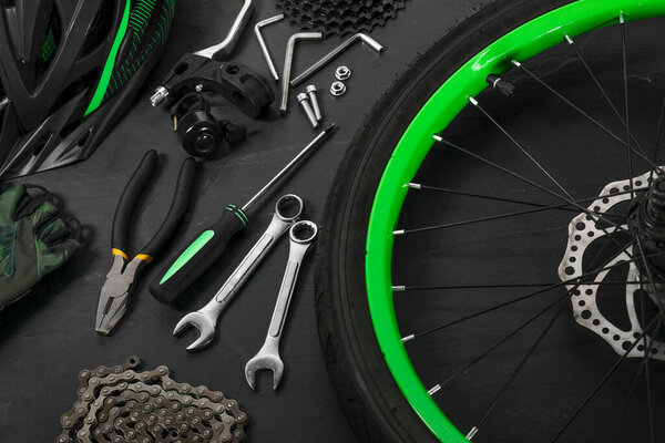 Parts of bicycle and tools on black background