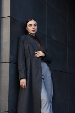 Dışarıda poz veren siyah ceketli güzel bir genç kadın.