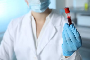 Laboratuvar testi. Doktor elinde kan örneğiyle test tüpü tutuyor, yakın plan.