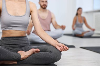 Yoga dersinde hasırlar üzerinde meditasyon yapan bir grup insan, yakın plan.