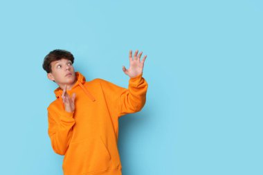 Açık mavi arka planda korkmuş genç bir çocuk. Metin için boşluk