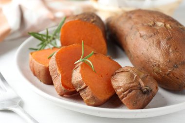 Lezzetli pişmiş tatlı patates ve biberiye masada, yakın plan.