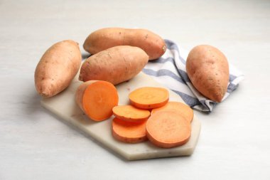 Taze patates ve mutfak havlusu beyaz masada, yakın plan.