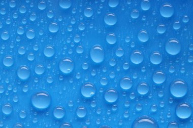 Su damlaları mavi arkaplanda, üst görünümde