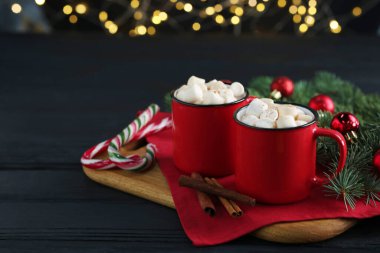 Lezzetli sıcak kakao içecekleri ve siyah tahta masada şekerleme, yakın plan. Metin için boşluk