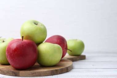 Beyaz ahşap masada farklı olgun elmalar. Metin için boşluk