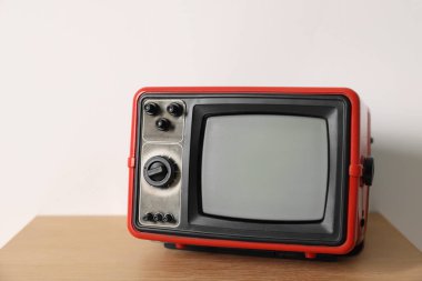Beyaz duvara karşı komodinin üzerindeki Retro TV. Metin için boşluk