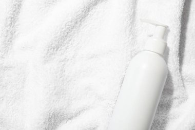 Yumuşak havluyla şampuan şişesinde, üst manzara. Metin için boşluk