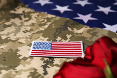 Gaziler Günü. Amerikan ordusu arması ve gül çiçekleri kamuflaj kumaşında, yakın plan