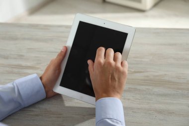 İşadamı ahşap masada tablet kullanıyor, yakın plan. Modern teknoloji