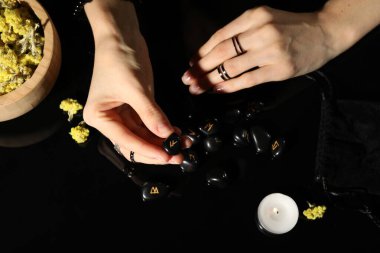 Woman with black runes at table, top view clipart