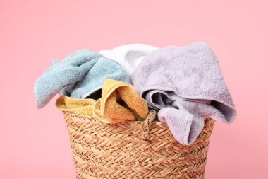 Pembe arka planda bir sepet dolusu çamaşır, yakın plan.