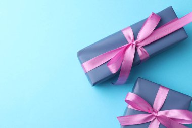 Açık mavi arka planda fiyonklu hediye kutuları düz yatıyordu. Metin için boşluk