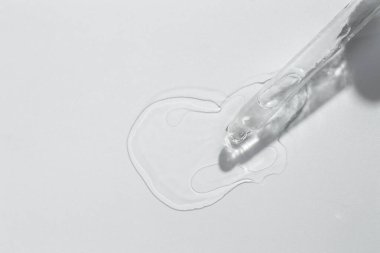 Açık gri arka planda kozmetik yağı ve pipet, üst görünüm