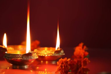Diwali kutlaması. Diya lambaları ve arkaplanda güzel çiçekler, yakın plan