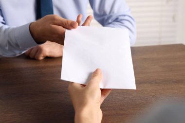 Yozlaşma konsepti. Ahşap masadaki adama para veren kadın, yakın plan.
