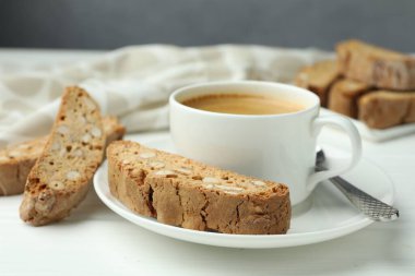 Geleneksel İtalyan badem bisküvileri (Cantucci) ve beyaz masada kahve, yakın plan.