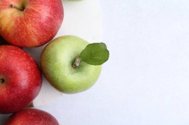 Açık gri masada taze olgun elmalar, üst manzara. Metin için boşluk