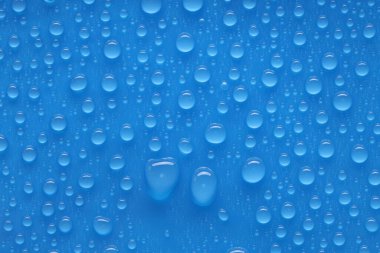 Su damlaları mavi arkaplanda, üst görünümde