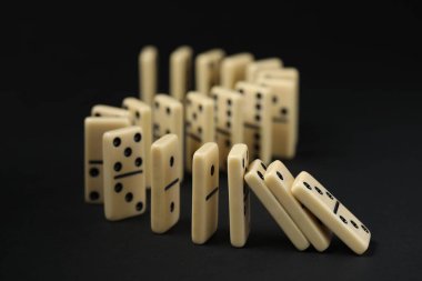 Domino etkisi. Kiremitler siyah arkaplana düşüyor