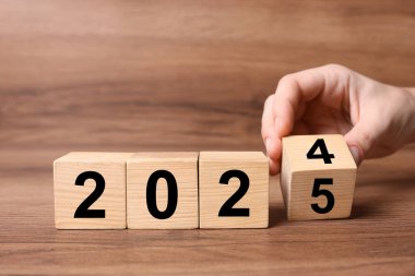 2025 Yeni Yıl. Masanın üzerinde tahtaya dönüşen kadın, yakın plan.