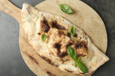 Gri desenli masada taze fesleğenle nefis bir calzone.