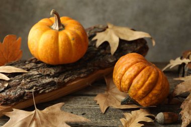 Fresh pumpkins and dry leaves on wooden table, closeup clipart