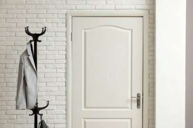 Koridorda gri ceketli metal askı