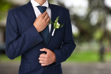Açık havada yaka çiçekli damat, yakın plan. Düğün aksesuarı