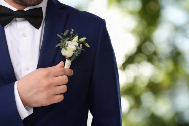 Açık havada yaka çiçekli damat, yakın plan. Düğün aksesuarı