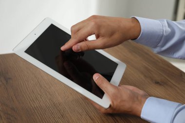 İşadamı ahşap masada tablet kullanıyor, yakın plan. Modern teknoloji