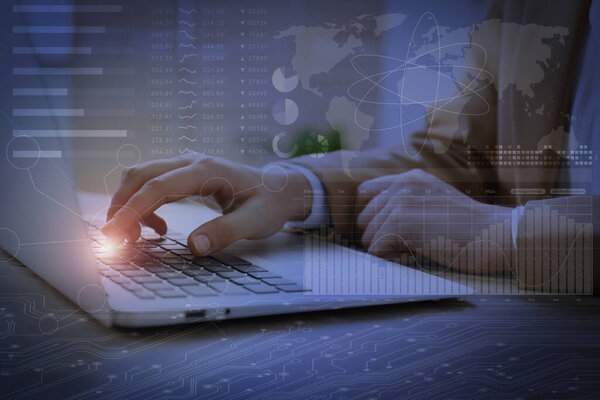 Технологии и бизнес. Женщина, работающая с ноутбуком за столом и графиками со схемами, двойной экспозицией