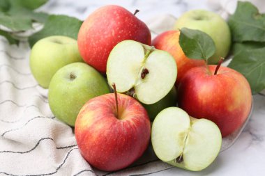 Beyaz masada farklı olgun elmalar, yakın plan.