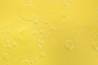 Sarı arka planda gerekli yağ kabarcıkları, makro görünüm. Kozmetik ürünü
