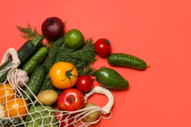 Vejetaryen ürünlerin teslimatı. Kırmızı arka planda farklı sebzeler ve meyvelerle dolu çantalar. Metin için boşluk