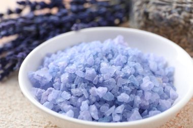 Kasede doğal deniz tuzu ve bej desenli masada lavanta, yakın plan.