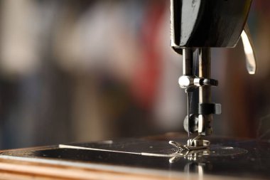 Bulanık arkaplanda ipliği olan dikiş makinesi, makro görünüm. Metin için boşluk