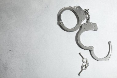 Metal zincir kelepçeler ve anahtarlar açık gri masada, üst tarafta. Metin için boşluk