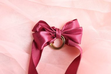 Alyanslar pembe tül kumaşında kurdeleyle bağlanmış.