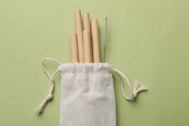 Bambu pipet içmek ve temiz fırça yeşil arka planda, üst görünüm