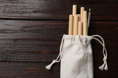 Bambu pipet içer ve tahta masada torba içinde temizlik fırçası, üst manzara. Metin için boşluk
