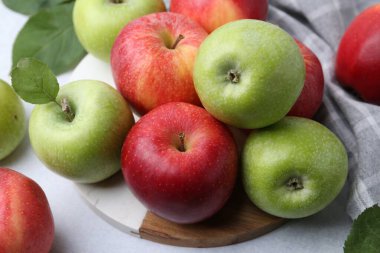 Açık gri masada taze olgun elmalar, yakın plan.