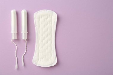 Regl pedi ve eflatun arka planda tamponlar, üst manzara. Metin için boşluk