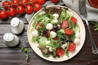 Lezzetli salata roka, marul, mozzarella peyniri, sebze ve çatal ahşap masa, düz yatak