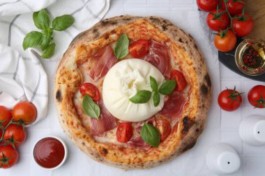 Delicious pizza with burrata cheese served on white tiled table, top view clipart