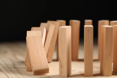Domino etkisi. Tahta masaya bloklar düşüyor, yakın plan.