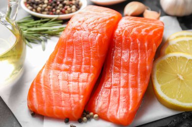 Koyu masada limon ve yağlı taze somon parçaları, yakın plan.