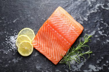 Koyu masada taze somon, limon ve biberiye.